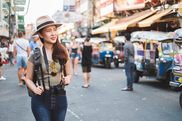 Photo woman looking away while walking on street in city