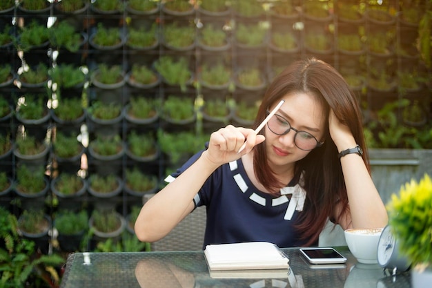 Photo woman looking at book while sitting in cafe