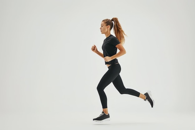 Woman Running in Black Top and Leggings