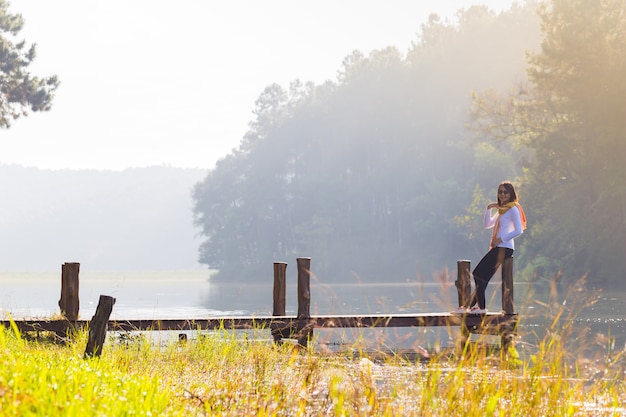 Woman sitting on a wooden bridge