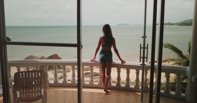 Photo woman standing on balcony ocean view in thailand resort