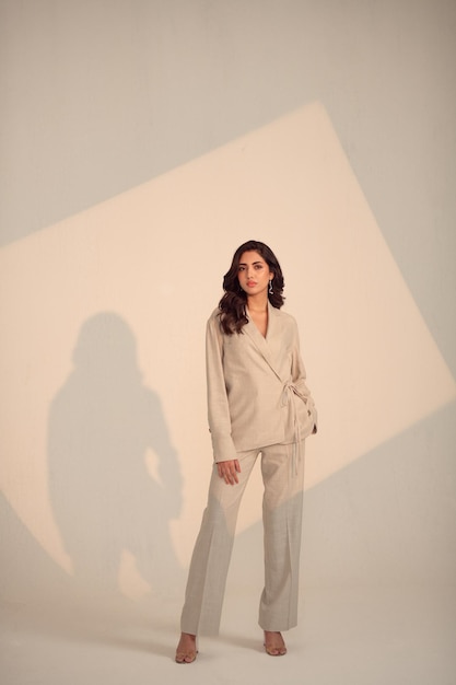 a woman stands in front of a wall with a shadow of a woman