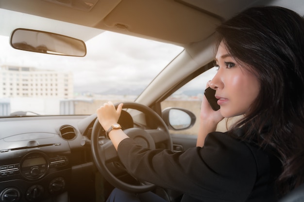 Photo 運転中に電話で話している女性