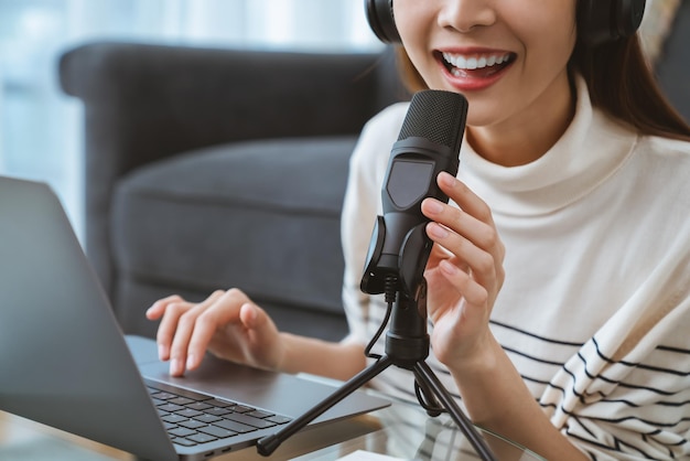 Woman use microphones wear headphones with laptop record podcast. Content creator concept.