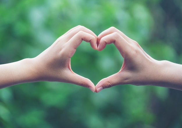 Women making heart shapes with their hands