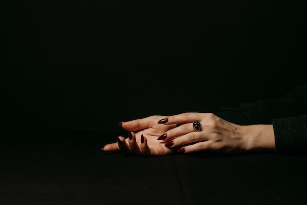 Women's hands with silver ring with garnet gem on finger with a manicure