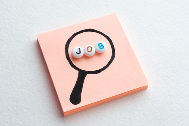 Photo the word job in a magnifying glass drawn on a sticker.