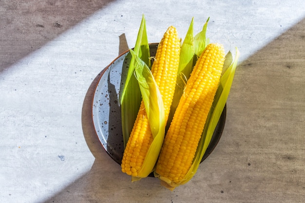 Yellow boiled corn on the cob on a plate