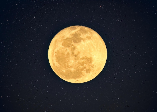 Photo yellow full moon with crater textured glowing with starry in night sky