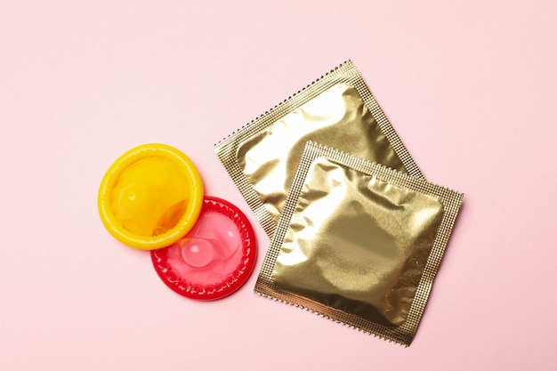 Photo yellow and red condoms on pink background