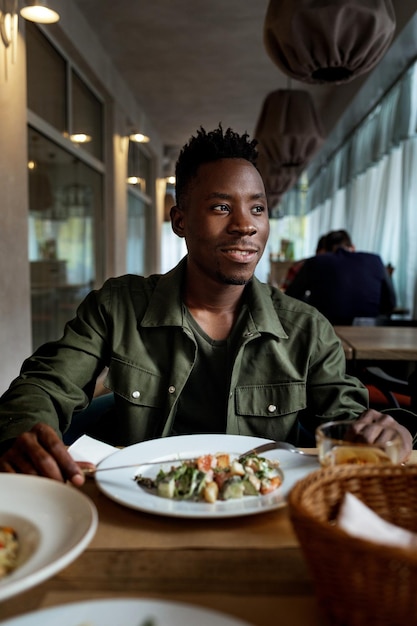 Young african american man is eating in a restaurant