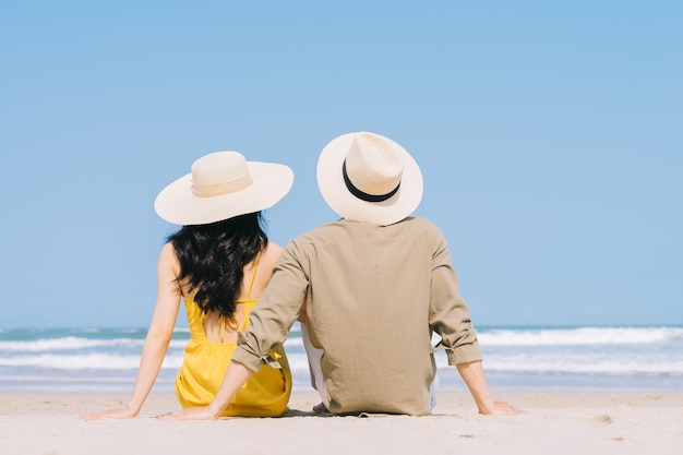 Photo young asian couple enjoying summer vacation on the beach