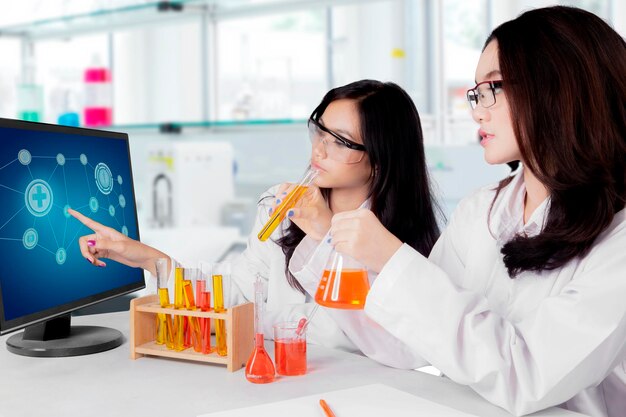 Photo young asian female scientists doing research isolated over white background