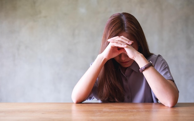 Photo a young asian woman feeling sad and stressed sick and headache at home