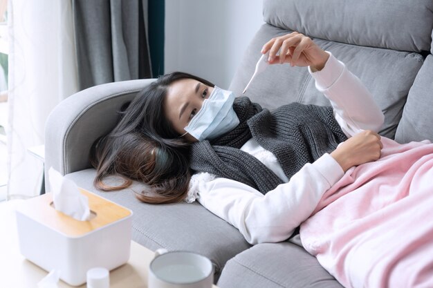 Photo young asian woman get sick with changing seasons lie down on couch