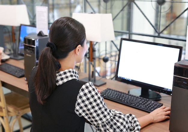 Photo young asian woman using desktop computer in the library