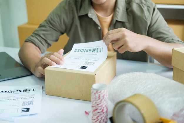 Young entrepreneur packing online order product for shipping