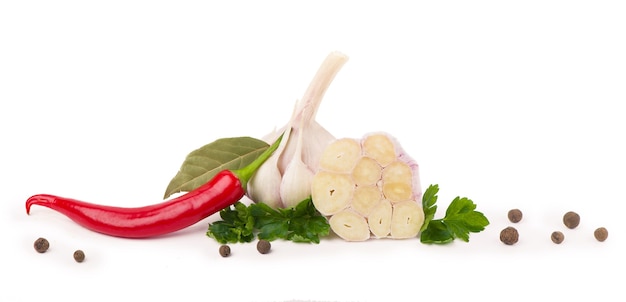 Young garlic with cilantro and black peppercorns on a white background. Copy space. Close up.