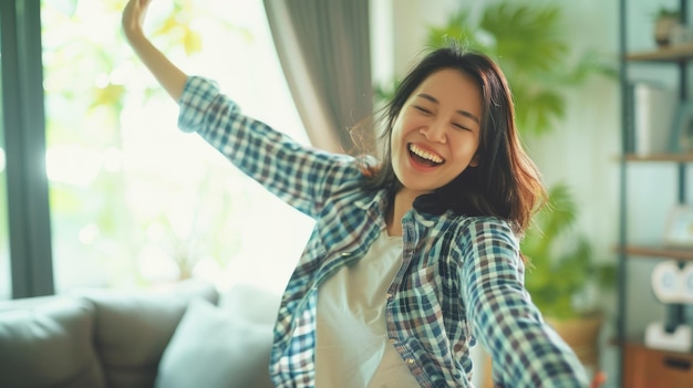 Photo young happy asian woman dancing at home