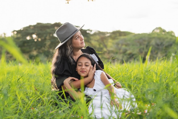 Photo young latin mother with her daughter lying on her chest while looking at the sky happy and grateful