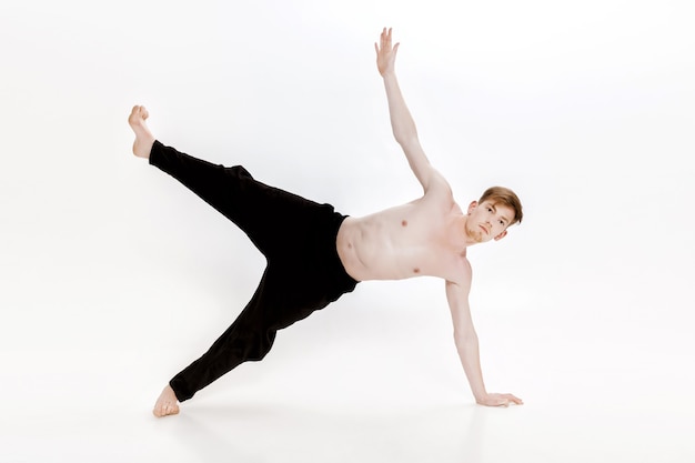 Young man doing yoga exercises studio shot on white background