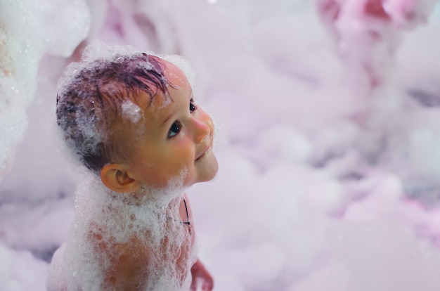 A young mother at the party with the child at a foam show