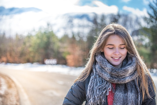 Young pretty woman on a road with snow in winter