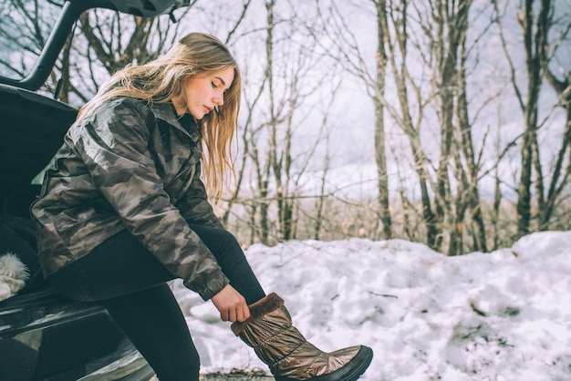 Young pretty woman on a road with snow in winter