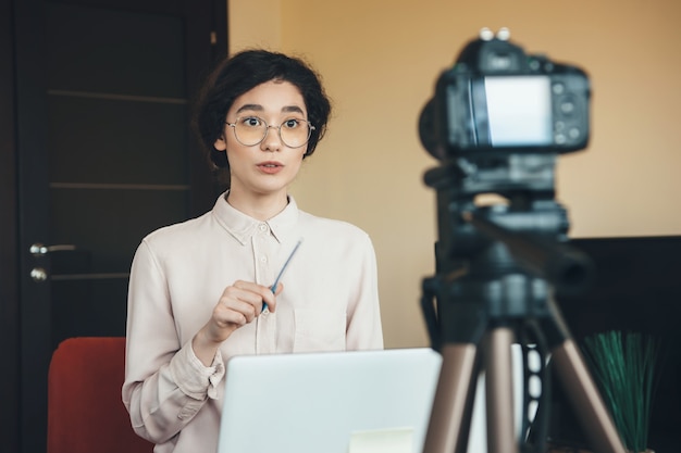 Young teacher is explaining something while online lesson using laptop