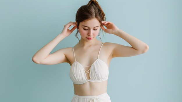 Photo a young woman poses in a stylish white outfit against a soft blue background radiating confidence and elegance