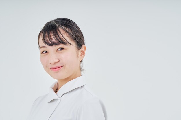 Young woman wearing a white coat indoors