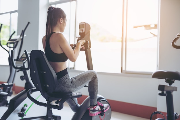 Young women are exercising in a fenced-in building.