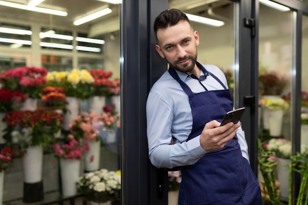 Zelfverzekerde zakenmanondernemer die bloemen en boeketten verkoopt