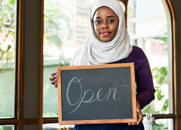 PSD islamic woman small business owner holding blackboard with smiling