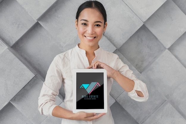 PSD medium shot of businesswoman holding a tablet with real estate