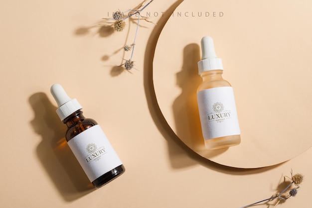 PSD mockup cosmetic bottles with a dropper on a beige surface with bright sunlight and hard shadows.