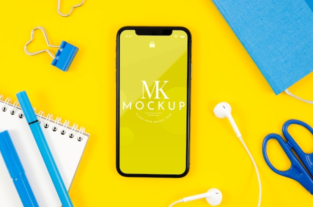 PSD top view smartphone mock-up with earphones and stationery