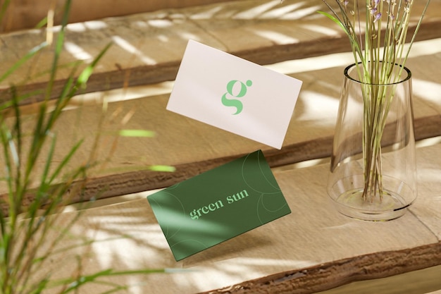 PSD white and green business card mockup floating over wooden plank natural background 3d render