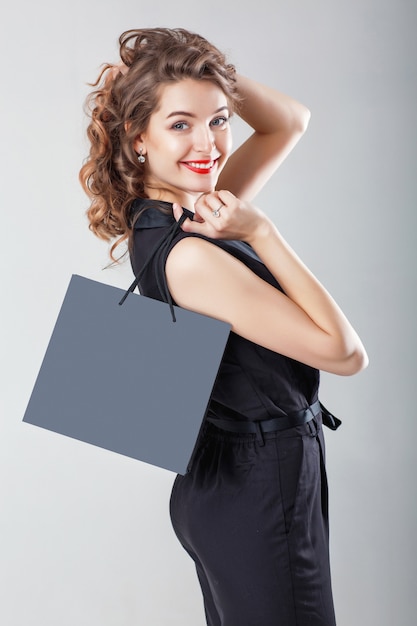 Woman in black with shopping bag. 