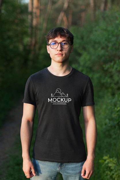 Young man wearing a mock-up t-shirt in the forest