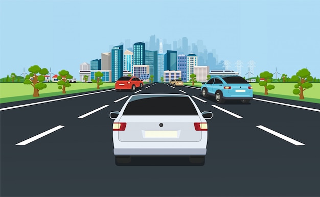 City traffic on highway with panoramic views of the modern city with skyscrapers and suburbs on background mountains, hills. Road with cars leading to the city.