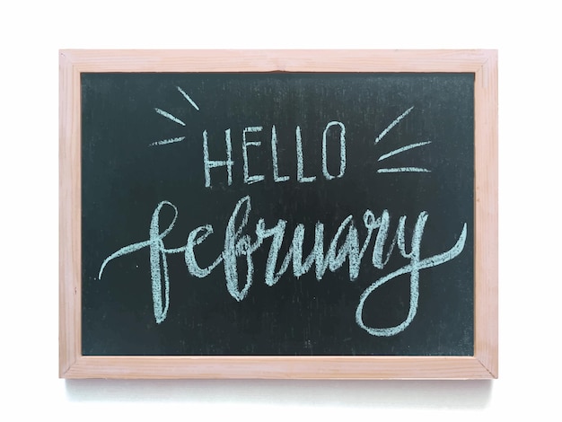 Handwritten text hello February  black chalkboard