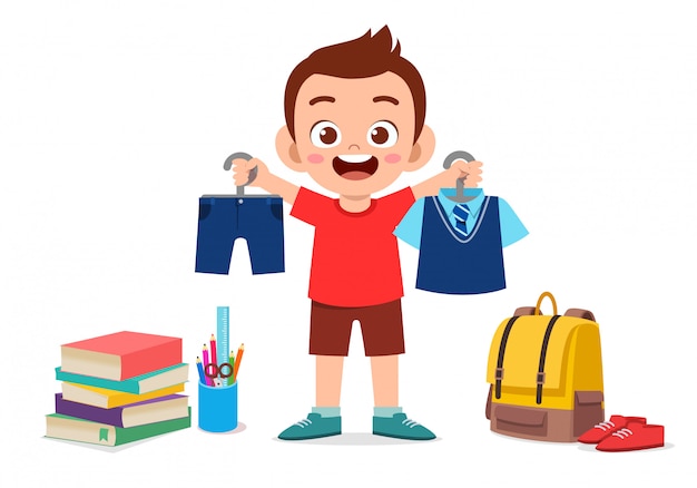 Happy cute little kid boy preparing uniform for school