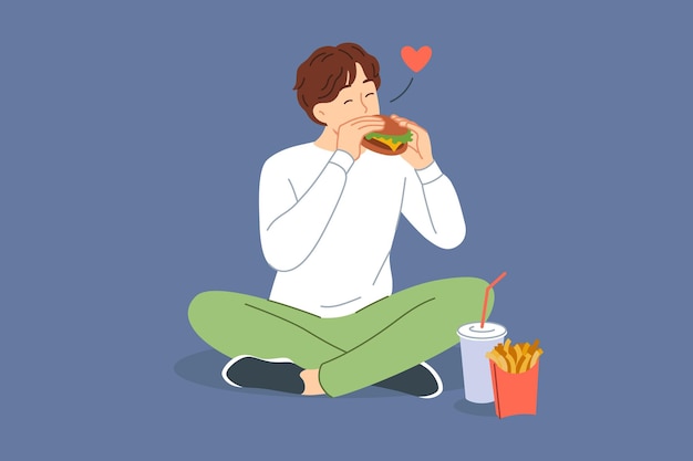 Vector man eats hamburger with sausage and cheese sitting on floor and enjoying taste of fast food