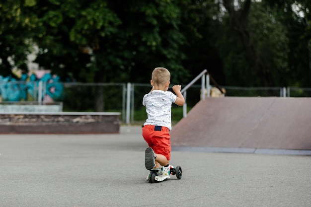 Aktywny chłopak jeżdżący na hulajnodze w letnim skateparku