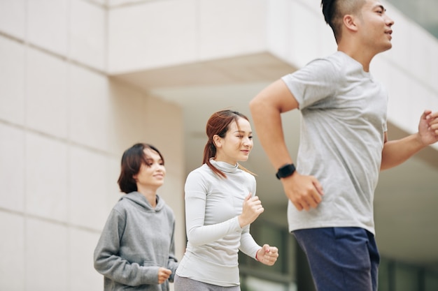 Zdjęcie ładna młoda wietnamka biegająca na świeżym powietrzu z grupą przyjaciół, aby przygotować się do maratonu