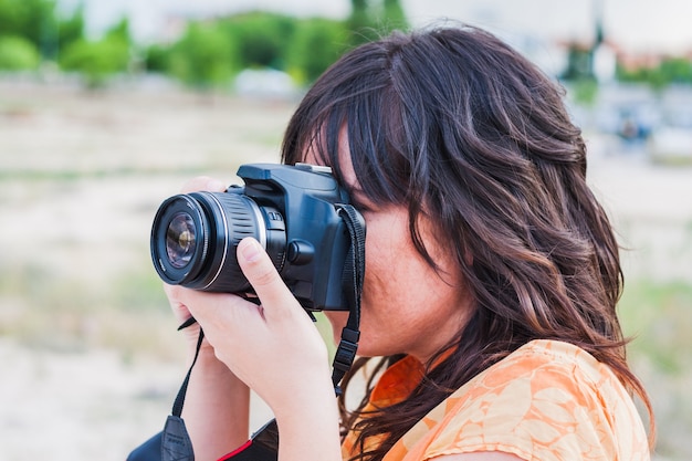 Młoda kobieta przy fotografowaniu z lustrzanką