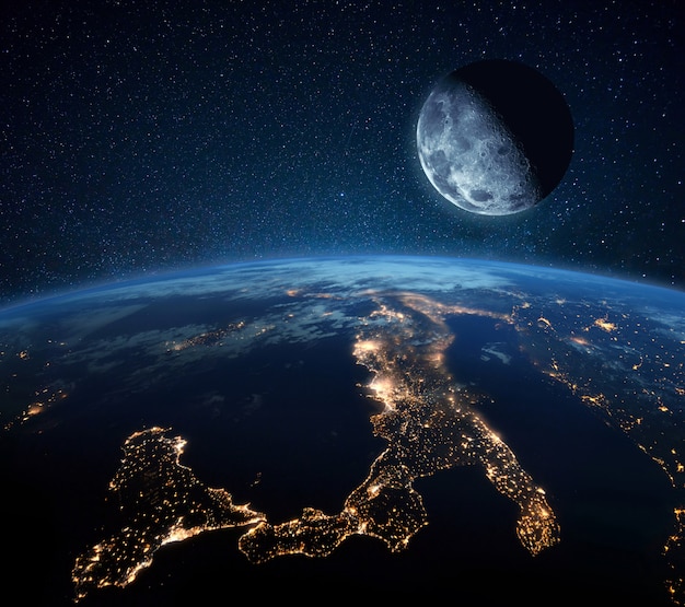 Niebieska planeta ziemia z miastami światłami w przestrzeni na gwiaździstym niebie z księżycem. Księżyc z kraterami w pobliżu planety. Życie nocne Włochy i Europa Środkowa