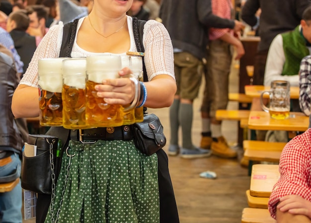 Oktoberfest Monachium Niemcy Kelner z tradycyjnym kostiumowym mienia piwami