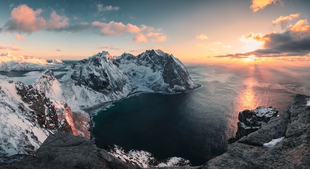 Zdjęcie panorama zachodu słońca nad górą ryten i plażą kvalvika zimą na lofotach